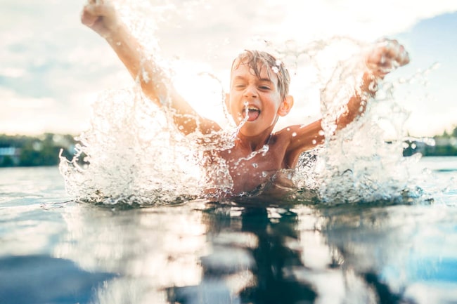 Junge plantscht im Wasser