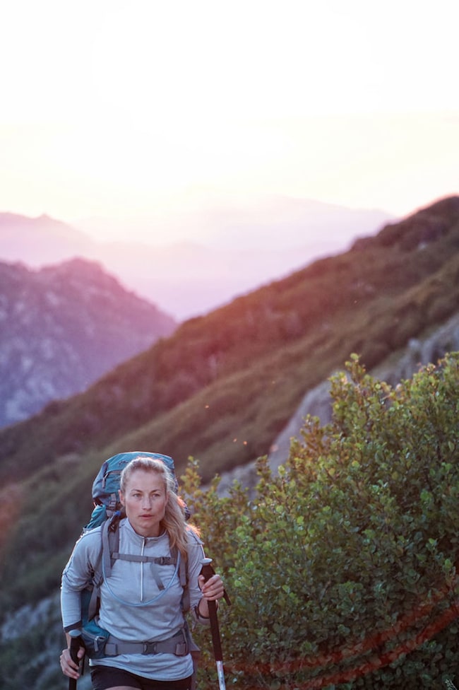 Frau beim Nordic Walking im Herbst bei Sonnenuntergang