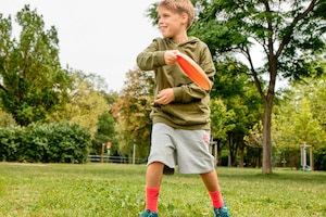 Junge, Bub, Kind, Park, grüne Wiese, Bäume, Frisbee, spielen, Bewegung, carpe diem