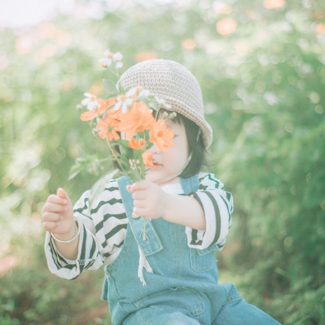 Alles Liebe zum Muttertag: Kleinkind mit selbstgepflückten Wiesenblumen