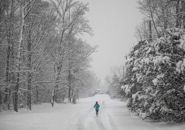 Frau läuft durch Winterlandschaft