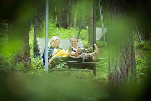 Zwei Personen auf einem Schaukelstuhl, Wald, Urlaub im Mühlviertel, Schaukel, Mann, Frau, schaukeln